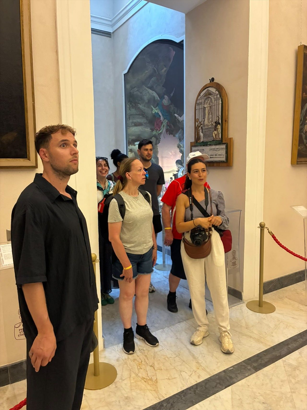 Partecipanti ascoltano la guida durante una visita dedicata all'arte locale